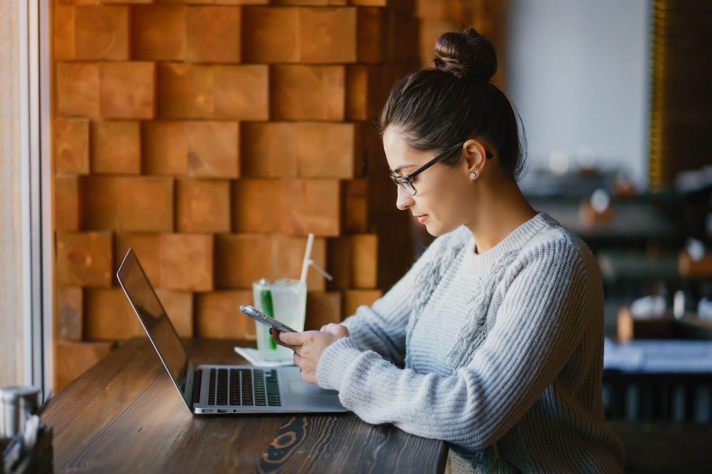 girl working on a laptop at a restaurant LP9X5KM