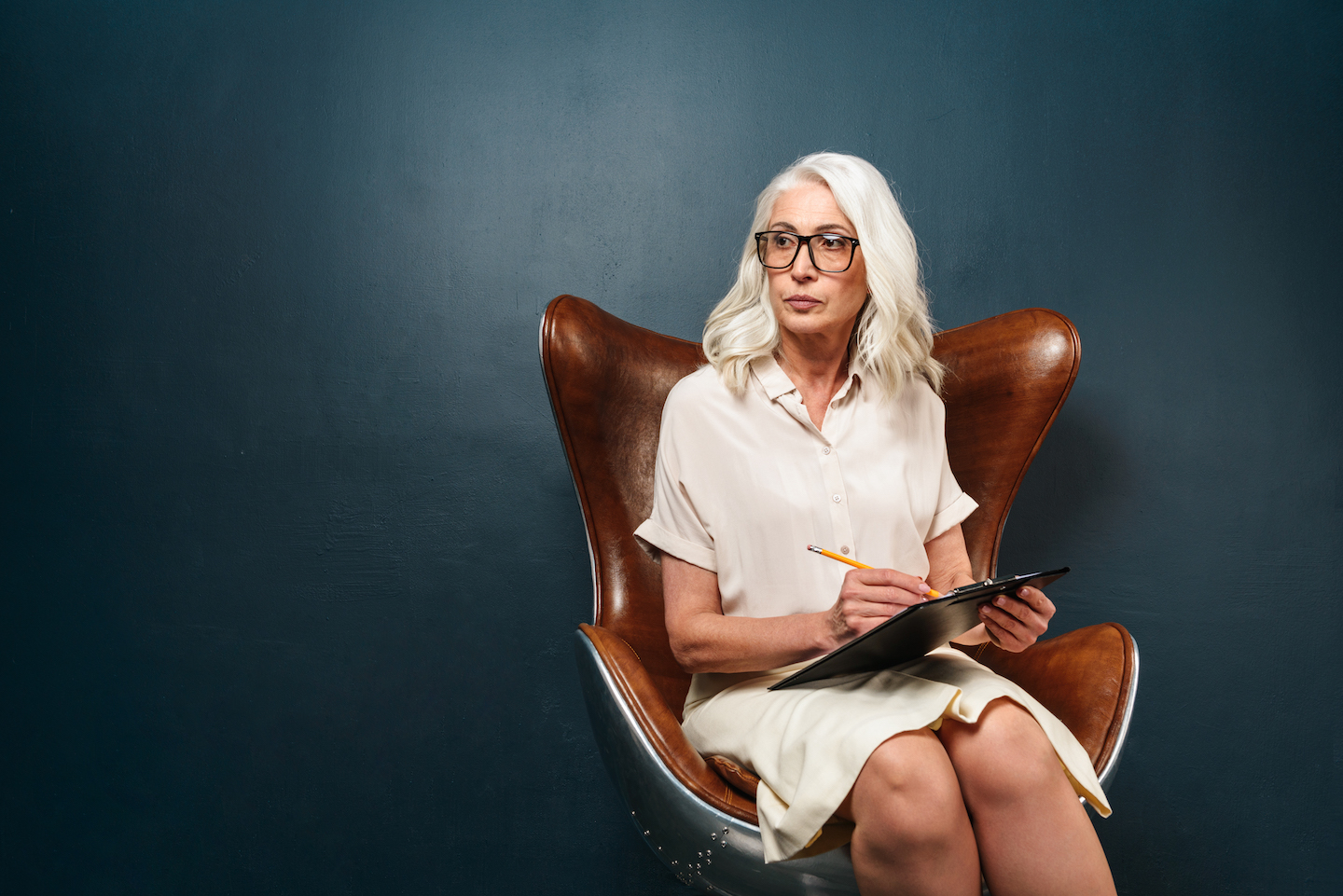 serious mature old woman holding clipboard with P5KFEXN