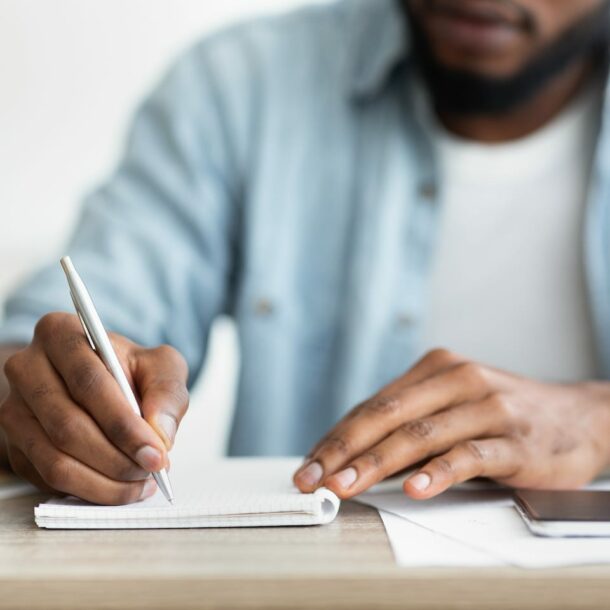 african american businessman writing down his TM5Y3F7