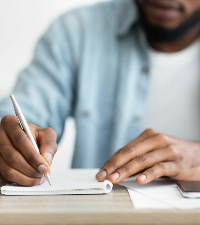 african american businessman writing down his TM5Y3F7
