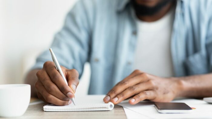african american businessman writing down his TM5Y3F7