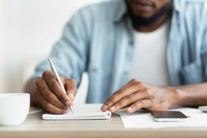 african american businessman writing down his TM5Y3F7
