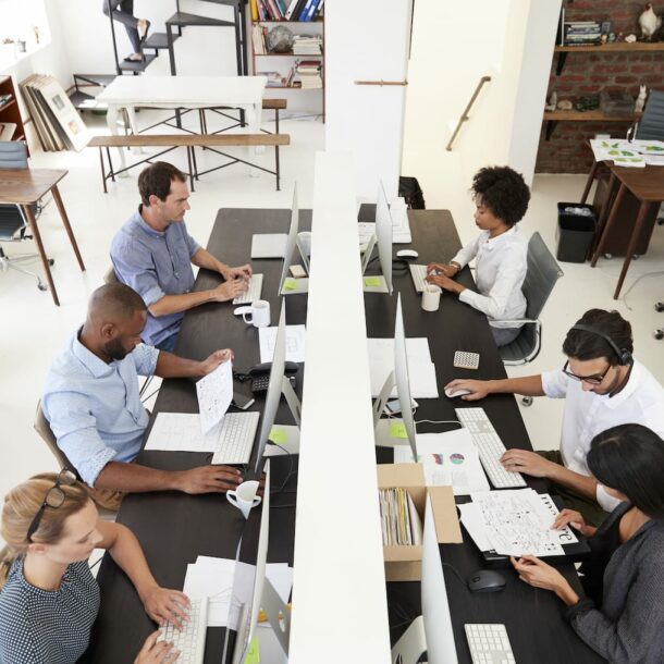 colleagues working at a busy open plan office PQMUBW3