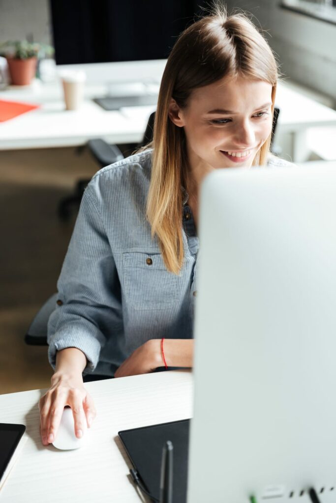 happy young woman work in office using computer PERMEN2