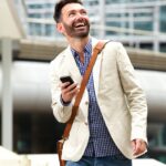 smiling mature man outdoors with mobile phone PB28ME5