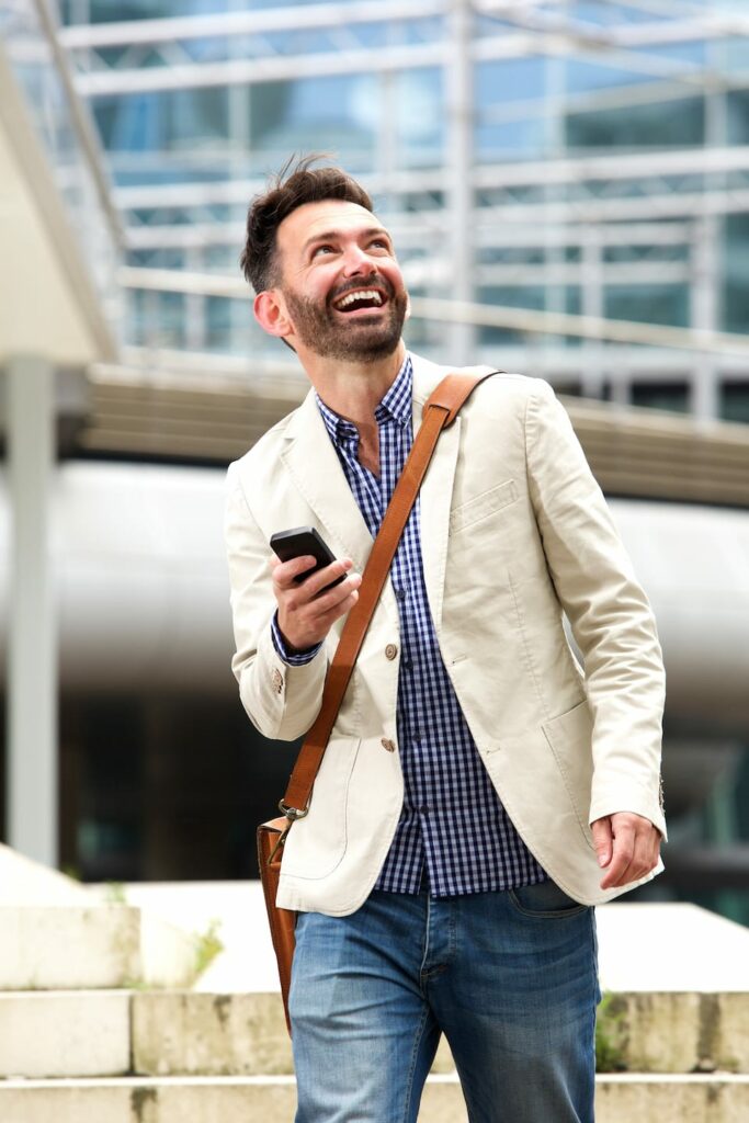 smiling mature man outdoors with mobile phone PB28ME5